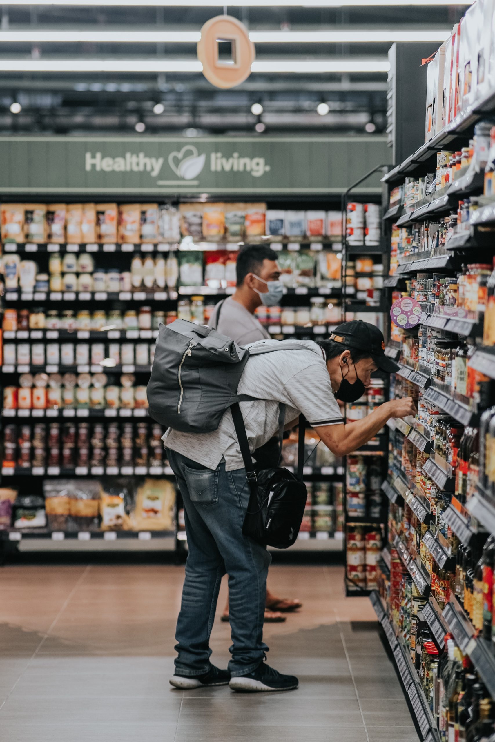 man grocery shopping in a pandemic with a mask on.